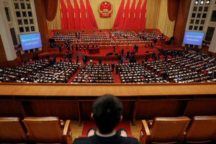 Delegates cast ballots during a vote on a constitutional amendment lifting presidential term limits, at the third plenary session of the National People's Congress (NPC) at the Great Hall of the People in Beijing